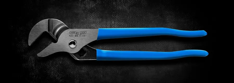 A pair of Channellock 420 tongue-and-groove pliers laid flat against a dark, scuffed metal backdrop: polished steel jaws open at the left, the CHANNELLOCK name and a "420 MADE IN U.S.A." stamp on the shank, and long blue vinyl grips fanning out to the right.