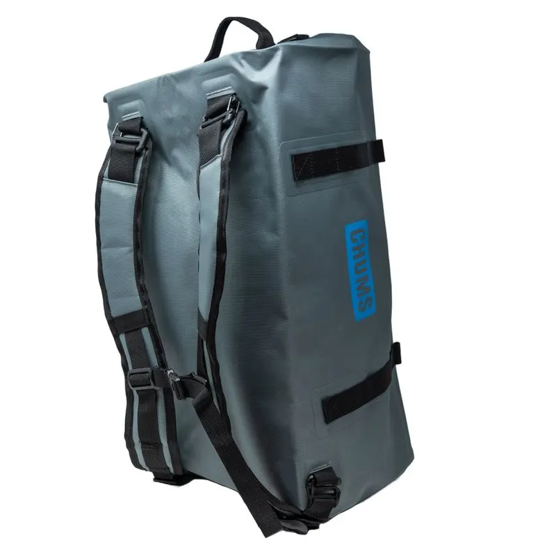 A grey waterproof rolltop duffel bag with black backpack straps and a blue CHUMS logo, shown standing upright at an angle against a white background.