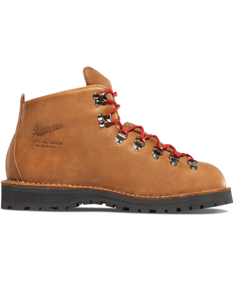 A tan leather hiking boot with a hooked-lace mountaineering design, red laces, and a black lug sole, shown in profile with "Danner, Portland, Oregon, Made in USA" stamped on the leather.