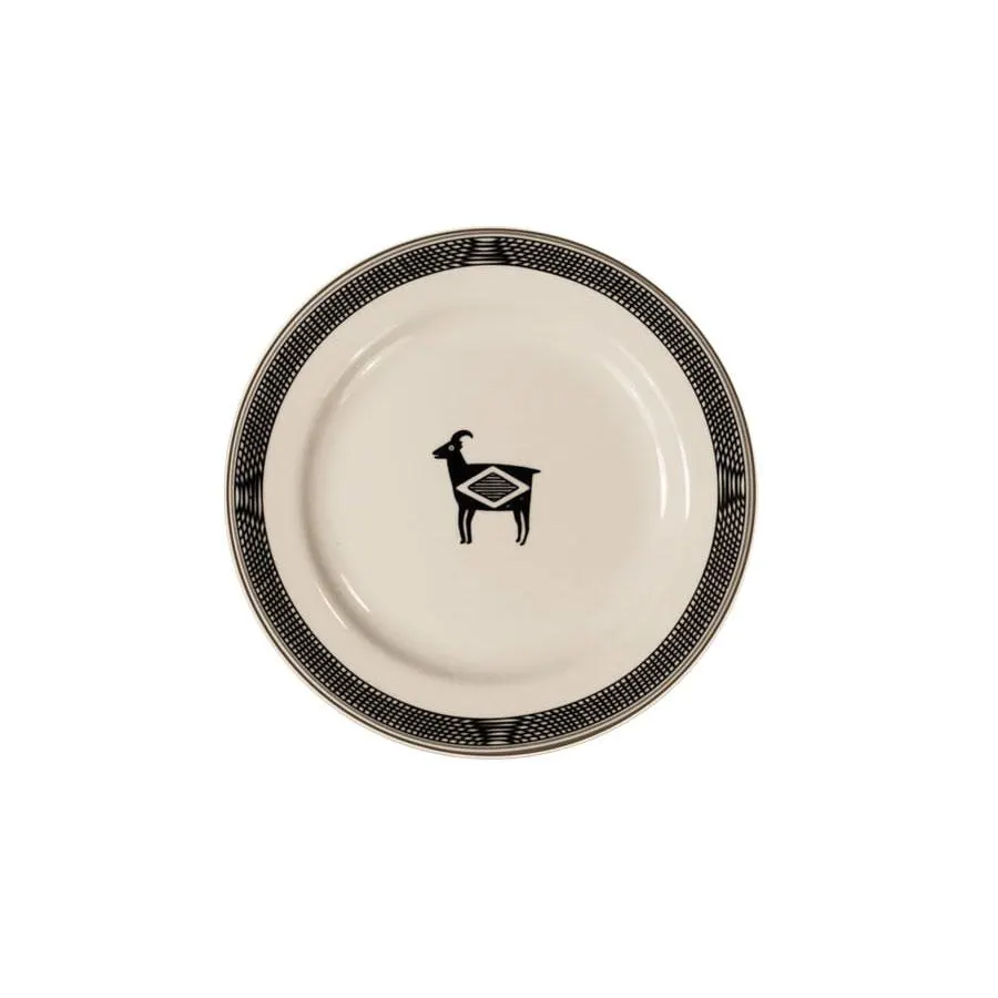 A round cream ceramic salad plate with a black Art Deco border pattern and a small black goat silhouette at center, on a white background.