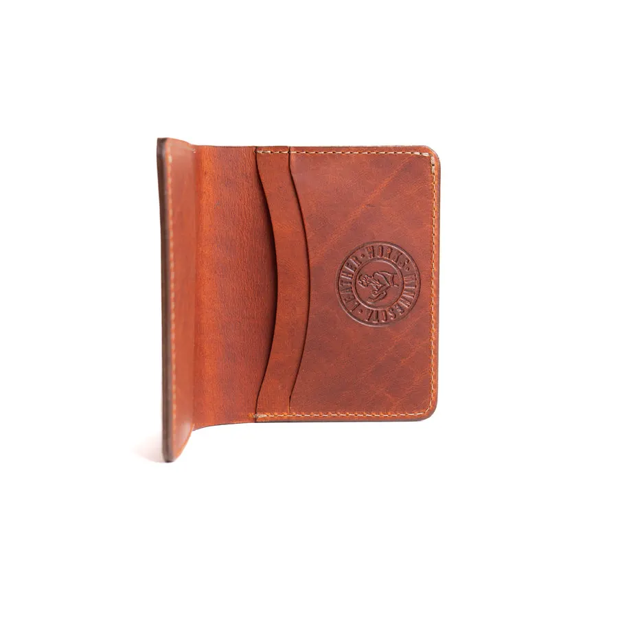 An open brown leather bifold wallet showing card slots and an embossed circular Leather Works Minnesota stamp, shot on white.