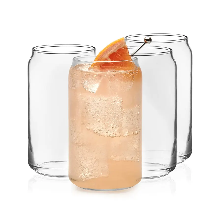 Three clear can-shaped tumbler glasses, the center one filled with an orange cocktail, ice and a grapefruit slice, against a white background.
