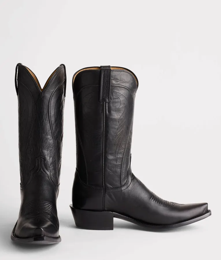 A pair of black cowhide cowboy boots with pointed square toes and hand-burnished western stitching on the shaft, shot on a white background.