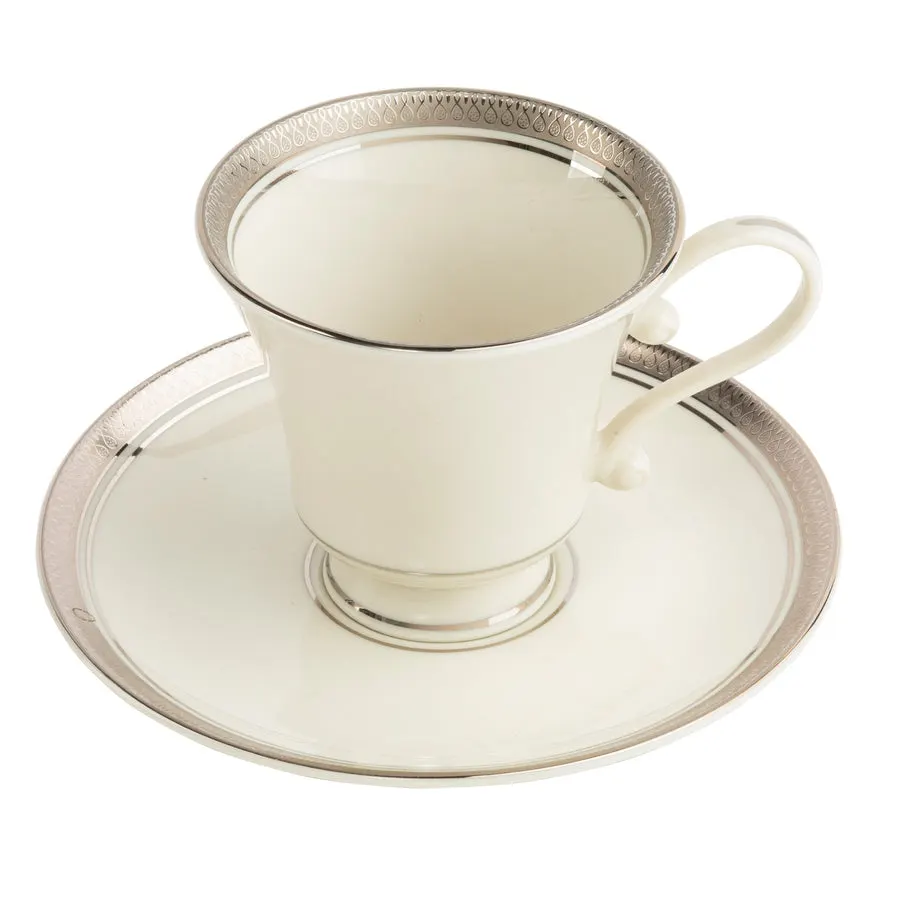 An ivory bone china teacup and saucer with a platinum rim band and platinum teardrop-pattern border, shot on white.