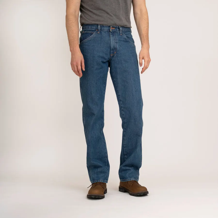 A man shown from the waist down wearing medium-blue stonewashed denim jeans and brown work boots, front view against a plain studio background.