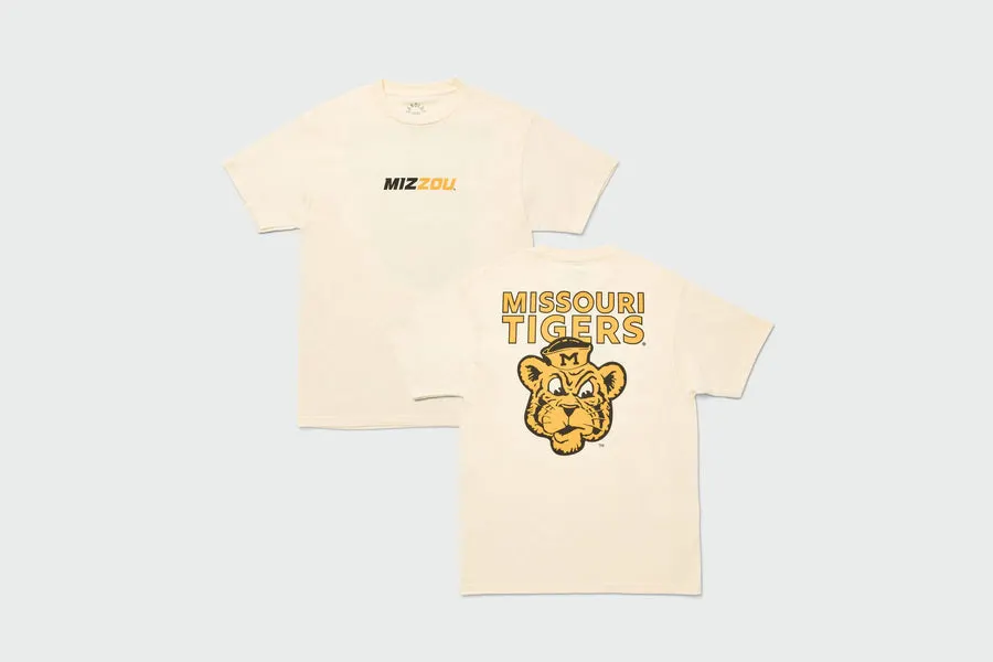 A cream short-sleeve t-shirt shown front and back, with a small 'MIZZOU' wordmark on the chest and a large Missouri Tigers mascot graphic on the back.