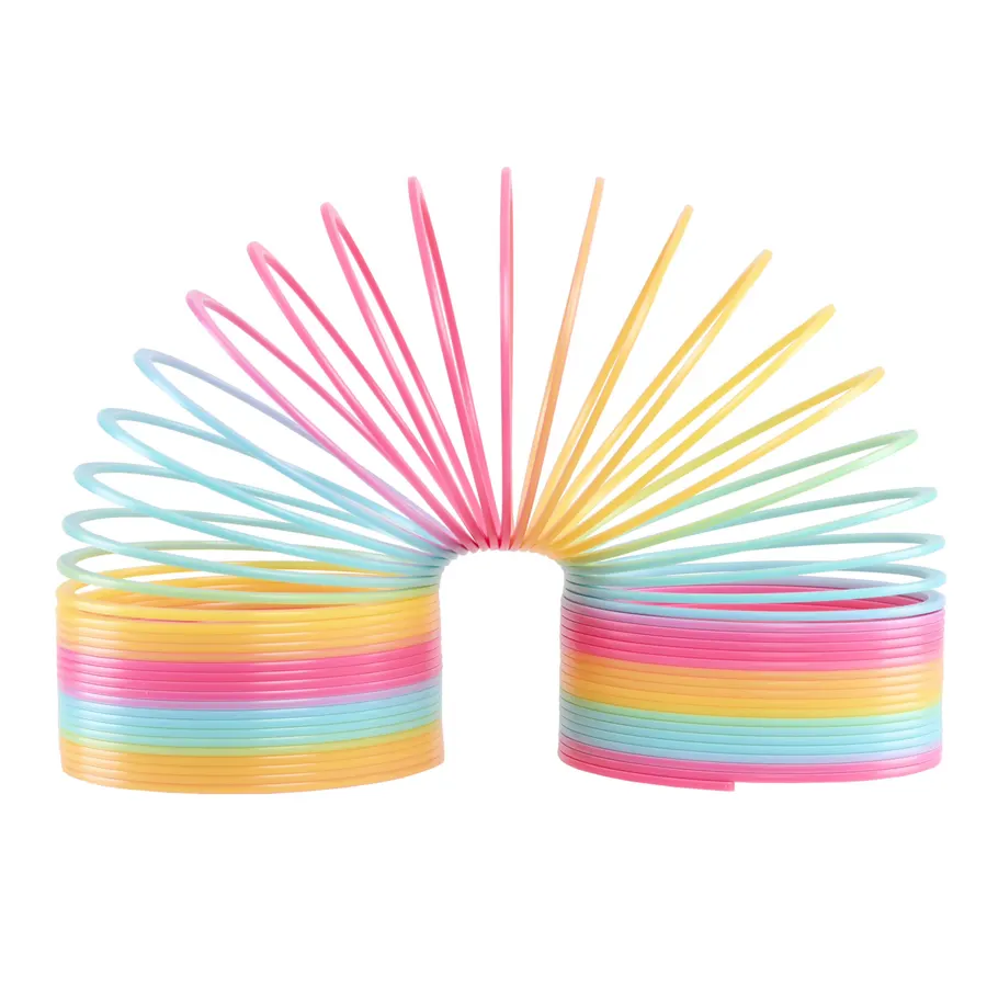 A rainbow-colored plastic coil spring toy in pastel pink, orange, yellow, and blue, arched into a loop against a white background.