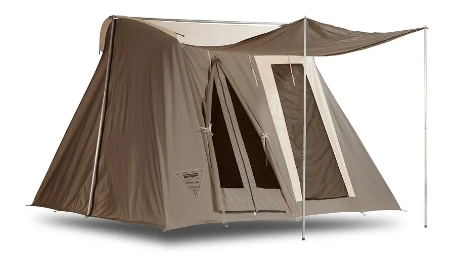 A tan canvas cabin tent (Traveler model) with an extended door awning propped on poles, shown at a three-quarter angle on a white background.