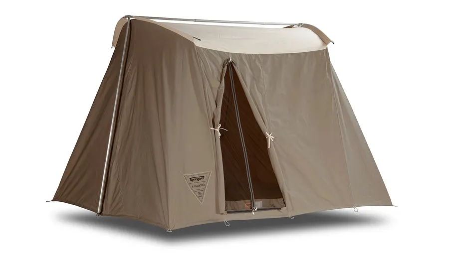 A light tan canvas cabin tent (Vagabond model) with a peaked roof and cross-braced door, shown at a three-quarter angle on a white background.