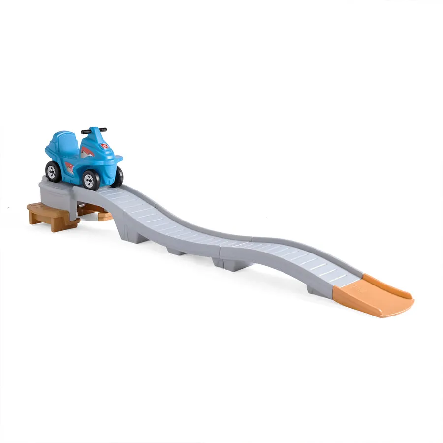 A blue plastic ride-on toy car with a red racing-stripe decal parked at the top of a long, wavy grey roller-coaster ramp with a tan curved slide at the bottom, photographed against a white background.