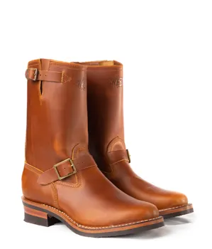 A pair of brown leather engineer boots with buckle straps and lug soles, photographed against a white background.