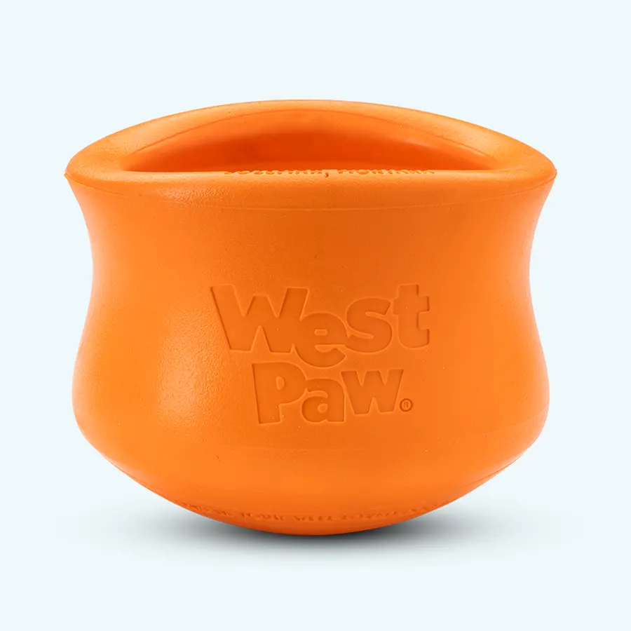 An orange rubber Toppl treat toy, a rounded cup shape embossed with the West Paw logo, on a plain light background.