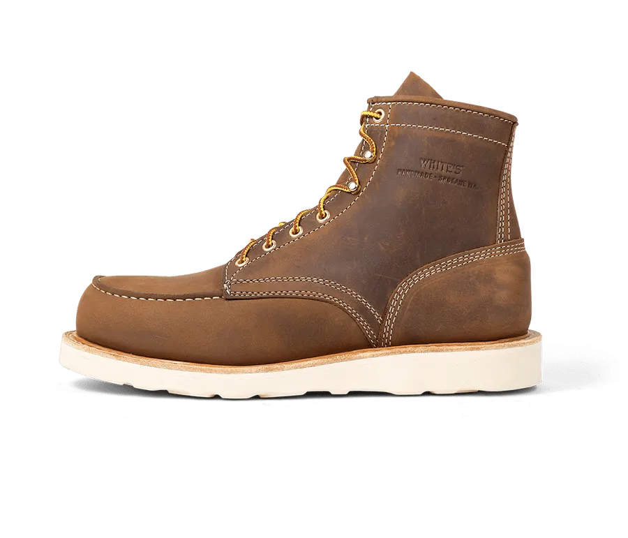A brown leather moc-toe work boot with a cream wedge sole and gold laces, shown in profile against a white background, embossed with the White's Boots shield logo.