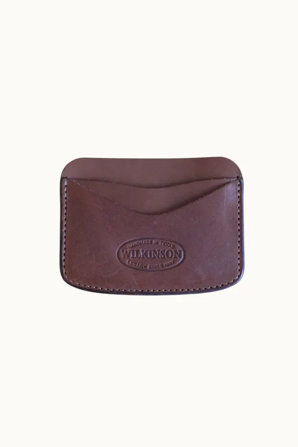 A brown leather card wallet with an embossed oval 'Wilkinson' maker's stamp, shot flat on a cream background.
